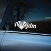 Plotrovaná nálepka i ❤️ jdm, vyrezávaný text s malým písmenom a symbolom srdca, v ktorom sú zobrazené slnečné lúče.