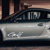 Plotrovaná nálepka s nápisom „Golf“ v dynamickom písme na dvere auta.