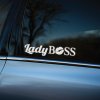 Plotrovaná nálepka na auto s textom „Lady Boss“, kde písmeno O tvorí biely otlačok pier v elegantnom kontrastnom prevedení.