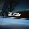 Plotrovaná nálepka Don't Fall In Love s nápisom a zlomeným srdcom, výrazný a zábavný dizajn pre bočné sklá.