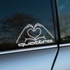 Plotrovaná nálepka s nápisom quattro a siluetou rúk vytvárajúcich srdce, decentný dizajn pre milovníkov Audi quattro.