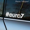 Na obrázku je biela nálepka s hashtagom "#euro7" nalepená na zadnom okne auta. Táto nálepka v modernom štýle "elegant" vyjadruje spojitosť s európskymi emisnými normami alebo automobilovou kultúrou orientovanou na novšie modely a technológie. Je vhodná pre vodičov, ktorí chcú zvýrazniť svoj postoj k ekologickým štandardom alebo zdôrazniť, že ich vozidlo spĺňa najnovšie technické požiadavky. Minimalistický dizajn nálepky dodáva autu čistý a štýlový vzhľad.