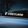 Plotrovaná nálepka na auto s logom VOGTLAND, dynamický font doplnený symbolom stylizovanej pružiny vľavo od nápisu.