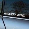 Plotrovaná nálepka na auto s menom „Letty Ortiz“ a symbolom kvapky krvi s krvným typom B+ v modernom typografickom prevedení.