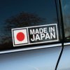 Na fotografii je nálepka s nápisom **"Made in Japan"**, ktorá je nalepená na okne auta. Dizajn obsahuje jednoduchý, ale ikonický symbol Japonska – červený kruh reprezentujúci slnko, spolu s výrazným textom. Táto nálepka je jasným prejavom hrdosti na japonský pôvod, často spájaný s kvalitnými autami, technológiou a kultúrou precíznosti.  Je ideálna pre majiteľov áut japonských značiek alebo fanúšikov japonskej kultúry, ktorí chcú svojmu vozidlu pridať prvok autenticity a zároveň zdôrazniť kvalitu a spoľahlivosť. Táto nálepka môže byť vhodným doplnkom pre tých, ktorí oceňujú japonský dizajn a inžinierske majstrovstvo.