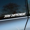 Nálepka s textom „STAY DIFFERENT“ v drsnom, štetcom písanom štýle, nalepená na okne sivého auta. Biele písmo vyniká na tmavom pozadí a dodáva autu rebelský a originálny vzhľad. Tento dizajn je ideálny pre vodičov, ktorí chcú vyjadriť svoju jedinečnosť a odvahu byť iný. Skvelá voľba pre tých, ktorí hľadajú štýlové a motivačné nálepky na svoje vozidlo.