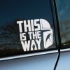 Plotrovaná nálepka na auto s nápisom „This is the way“, helmou Mandaloriana a siluetou postavy, ideálna pre fanúšikov Star Wars.
