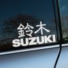 Elegantná nálepka na auto s nápisom "SUZUKI" a japonskými znakmi 鈴木 (Suzuki), umiestnená na zadnom okne šedého automobilu. Táto štýlová dekorácia dokonale zvýrazní vašu lásku k japonskej značke a pridá vášmu vozidlu osobitý vzhľad. Vyberte si kvalitné auto nálepky pre váš Suzuki a vylepšite jeho dizajn.