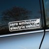 Plotrovaná nálepka „zero emission electric vehicle“ s ikonou listu. Perfektná nálepka na auto pre zvýraznenie ekologickej jazdy.