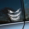 Plotrovaná nálepka na auto so strašidelnou démonickou tvárou a výrazne ostrými zubami, ideálna pre fanúšikov temných motívov.