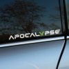 Plotrovaná nálepka s logom Apocalypse v štylizovanom písme s výrazným zeleným prvkom v tvare písmena Y.