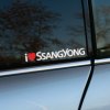 Plotrovaná nálepka s textom „I ♥ SSANGYONG“, kde červené srdiečko vyjadruje vášeň pre odolné SUV a off-road modely tejto značky. Skvelý doplnok pre fanúšikov.