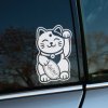 Plotrovaná nálepka Maneki Neko na okne auta, detailná verzia s veselým výrazom, obojkom a mincou s nápisom „金運“ (Kin’un), ktorá priťahuje bohatstvo.