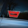 Plotrovaná dvojfarebná nálepka na auto s logom WARN v tvare písmena W a čiernym nápisom uprostred.