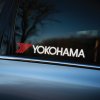 Plotrovaná dvojfarebná nálepka s logom YOKOHAMA a červeným šípovým motívom z čiar vľavo od názvu značky.