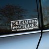 Plotrovaná nálepka DREAM CHASER s motivačným textom a japonským prepisom, zakončená sloganom „No dreams no drive“.