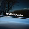 Plotrovaná nálepka na auto s nápisom „Tourneo Custom“ v štýle originálneho loga pre model Ford Tourneo Custom.