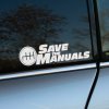 Plotrovaná nálepka na auto s nápisom „Save the Manuals“ a ikonou radiacej páky ako podpora manuálneho radenia.