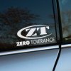 Plotrovaná nálepka na auto s logom Zero Tolerance, výrazné iniciály ZT v oválnom ráme a nápisom „Zero Tolerance“ pod nimi.