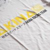 Potlač na tričku s nápisom „AKINA SPEED STARS“ a japonským textom, pretekársky motív na bielom textile.