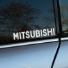 Plotrovaná nálepka na auto s jednoduchým bielym nápisom „MITSUBISHI“ v čistom bezpätkovom písme.