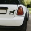 Plotrovaná nálepka na auto so siluetou jazvečíka a výrazným anglickým nápisom „Dog on Board“.