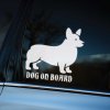 Plotrovaná nálepka na auto s charakteristickým obrysom welsh corgiho a anglickým textom „Dog on Board“, vhodná pre mestské autá.