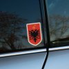 Tlačená nálepka s albánskym erbom, čierny dvojhlavý orol na červenom štíte so zlatým prilbovým znakom Skanderbega nad ním.
