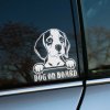 Plotrovaná nálepka s realistickým motívom beagla s veľkými očami a textom „Dog on board“, ideálna pre milovníkov plemena.