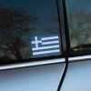 Tlačená nálepka grécka vlajka s modro-bielymi pruhmi a krížom, jednoduchý štátny motív vhodný ako nálepka na auto alebo kufor.