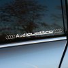 Plotrovaná nálepka na auto s nápisom Audi quattro a logom značky, vhodná pre elegantný a športový vzhľad vozidla.