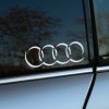 Plotrovaná nálepka so štyrmi prepojenými kruhmi v tieni dizajne loga Audi, decentný motív pre elegantný tuningový štýl.