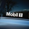 Plotrovaná nálepka s logom značky Mobil 1, jednoduchý dizajn s nápisom „Mobil“ a čiernym štvorcom obsahujúcim číslo 1.