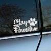 Plotrovaná nálepka s nápisom „Stay Pawsitive“ v ozdobnom fonte a siluetou labky, ideálna pre milovníkov psov.