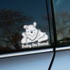Plotrovaná nálepka s postavou medvedíka, ktorý sa usmieva a pod ním sa nachádza presný nápis v znení Baby On Board.
