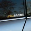 Plotrovaná nálepka s logom výrobcu podvozkov, ktorú tvorí dizajnový grafický symbol a presný nápis BC RACING.