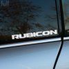 Plotrovaná nálepka s textom RUBICON v hrubých písmenách, model vozidla Jeep Wrangler.