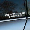 Plotrovaná nálepka s nápisom „CAMARO" v technickom písme a pod ním nápis v Cybertroniánskom písme Transformers.