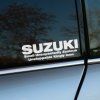 Plotrovaná nálepka s humorným akronymom SUZUKI – Small Unexpectedly Zealous Unstoppable Kingly Icon.