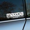 Plotrovaná nálepka s nápisom mazda a akronymom MAZDA – MAGNIFICENTLY AFFORDABLE ZOOM DRIVING ART.