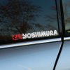 Plotrovaná nálepka na auto s logom YOSHIMURA, biely text s linkovým efektom a červený japonský nápis v hranatom poli.