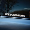 Plotrovaná nálepka na auto s logom YOSHIMURA, biely linkový nápis doplnený japonským znakom ヨシムラ v hranatom ráme.