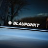 Plotrovaná nálepka na auto s logom BLAUPUNKT a typickým kruhom naľavo od názvu v mierne šikmom reze písma.
