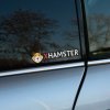 Nálepka na zadnom okne auta s logom "XHamster" a ikonickým obrázkom škrečka. Táto nálepka je určená pre ľudí s odvahou a zmyslom pre humor, ktorí chcú pridať svojmu vozidlu netradičný a provokatívny vzhľad. Ideálny spôsob, ako na cestách zaujať a pobaviť.