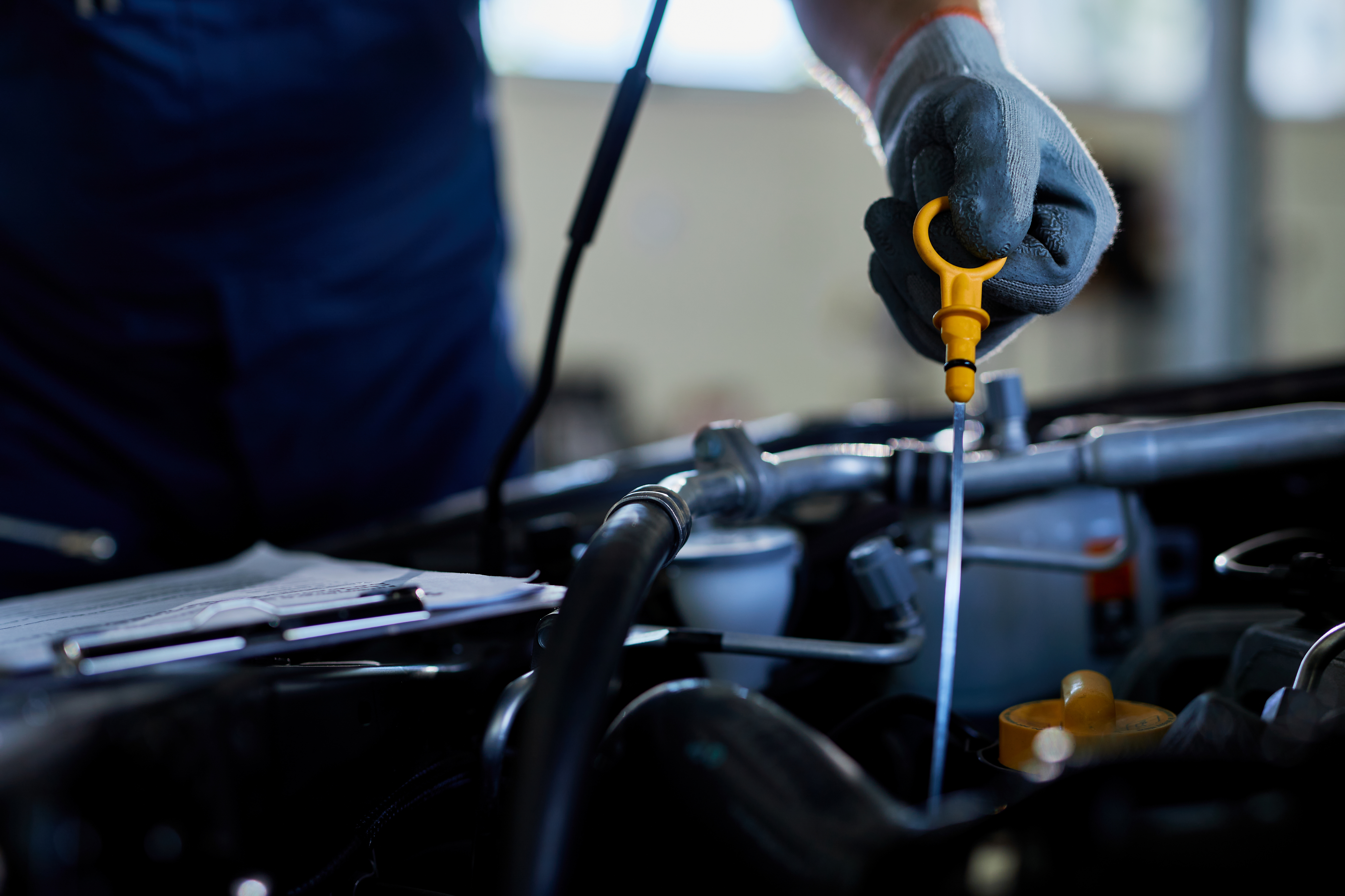 closeup-auto-repairman-checking-car-oil-workshop