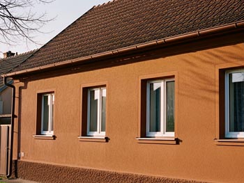 srovnání fasády s impregnací a bez - vlevo zelená fasáda od řas, vpravo čistá naimpregnovaná fasáda