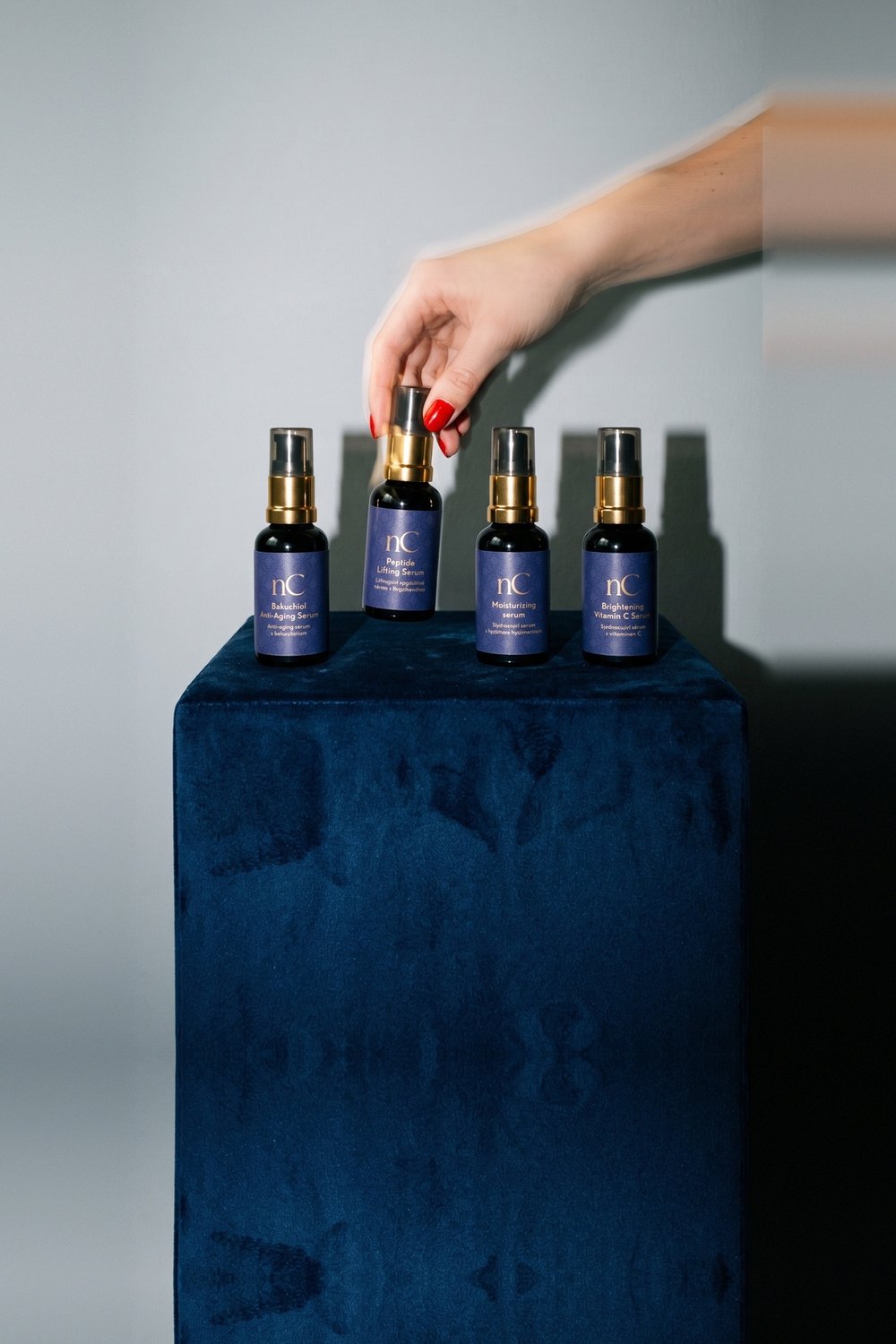 Ruka bere jedno ze čtyř sér nanoSPACE Cosmetics z modré sametové kostky
