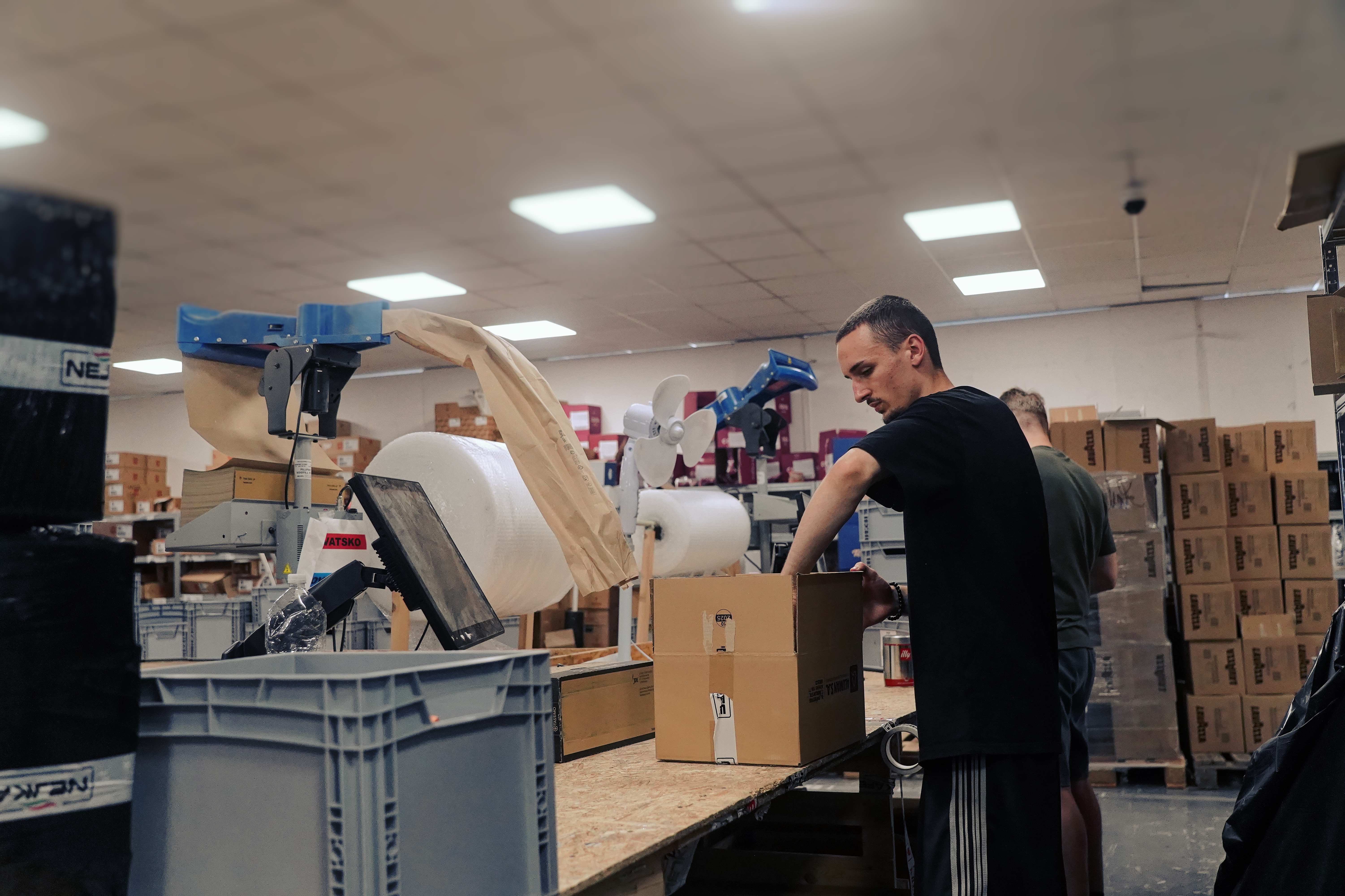 Colleague packing an order at a packing station