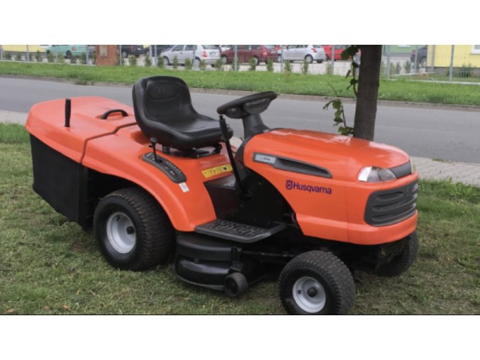 zahradní traktor husqvarna tc 139t oranžové barvy na trávě u silnice