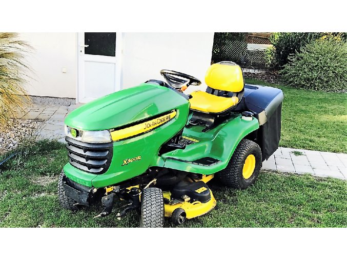 zahradní traktor john deere x300r zelené barvy na trávníku u domu